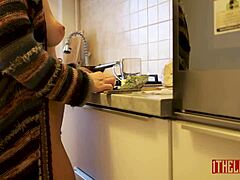 Attraktiv kone koker naken i kjøkkenet