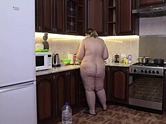 En vakker fet kvinne med en dampende rumpe liker å lage mat uten klær i en hjemmelaget video