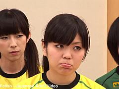 Unge japanske piger lærer af deres træner i en varm gruppetime