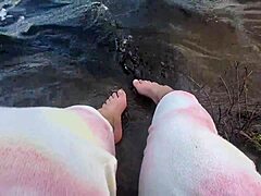 Mikas stora och håriga fötter njuter av barfota lek i vattnet
